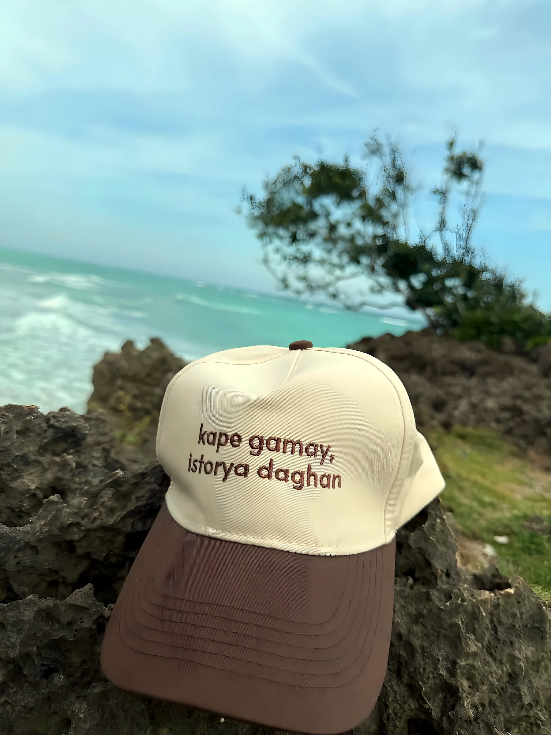 The same cap resting on a rock above the sea.